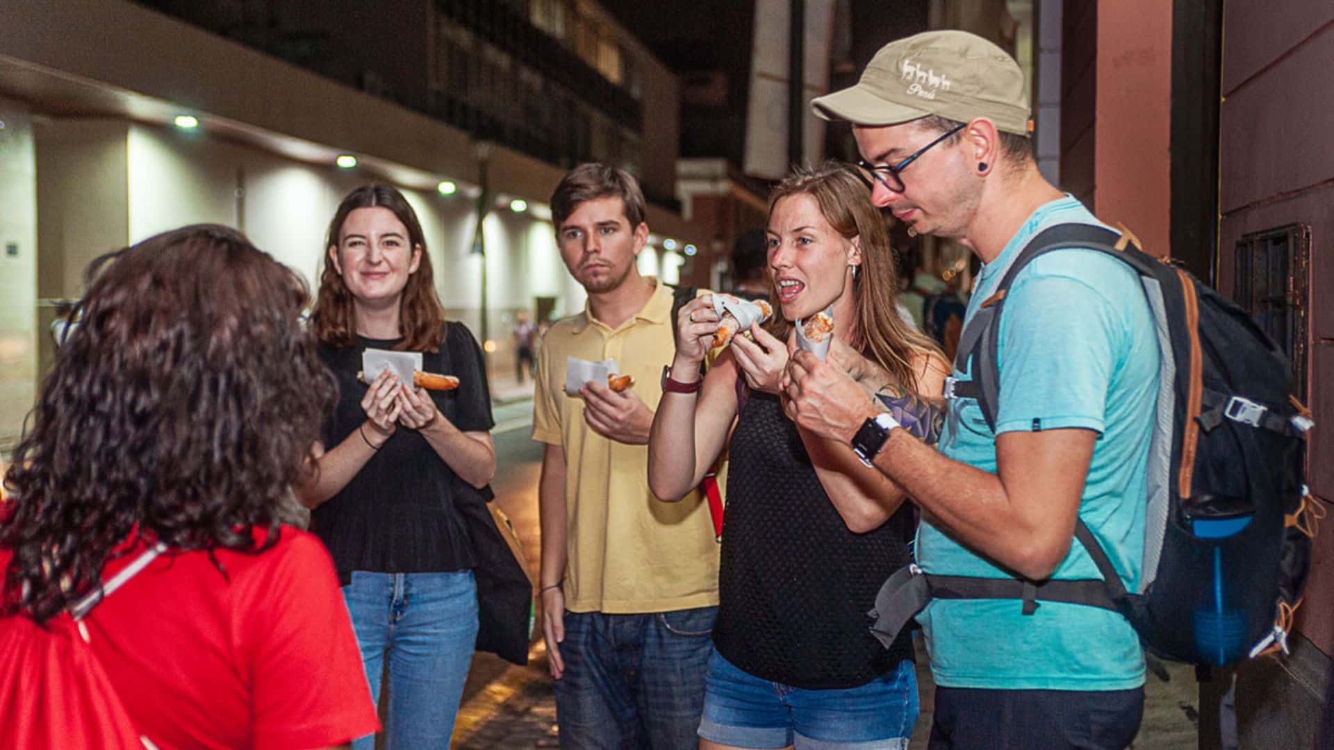 The group is enjoying a very popular dessert called Churro prepared with flour cooked in oil and with different types of fillings | Responsible Travel Peru