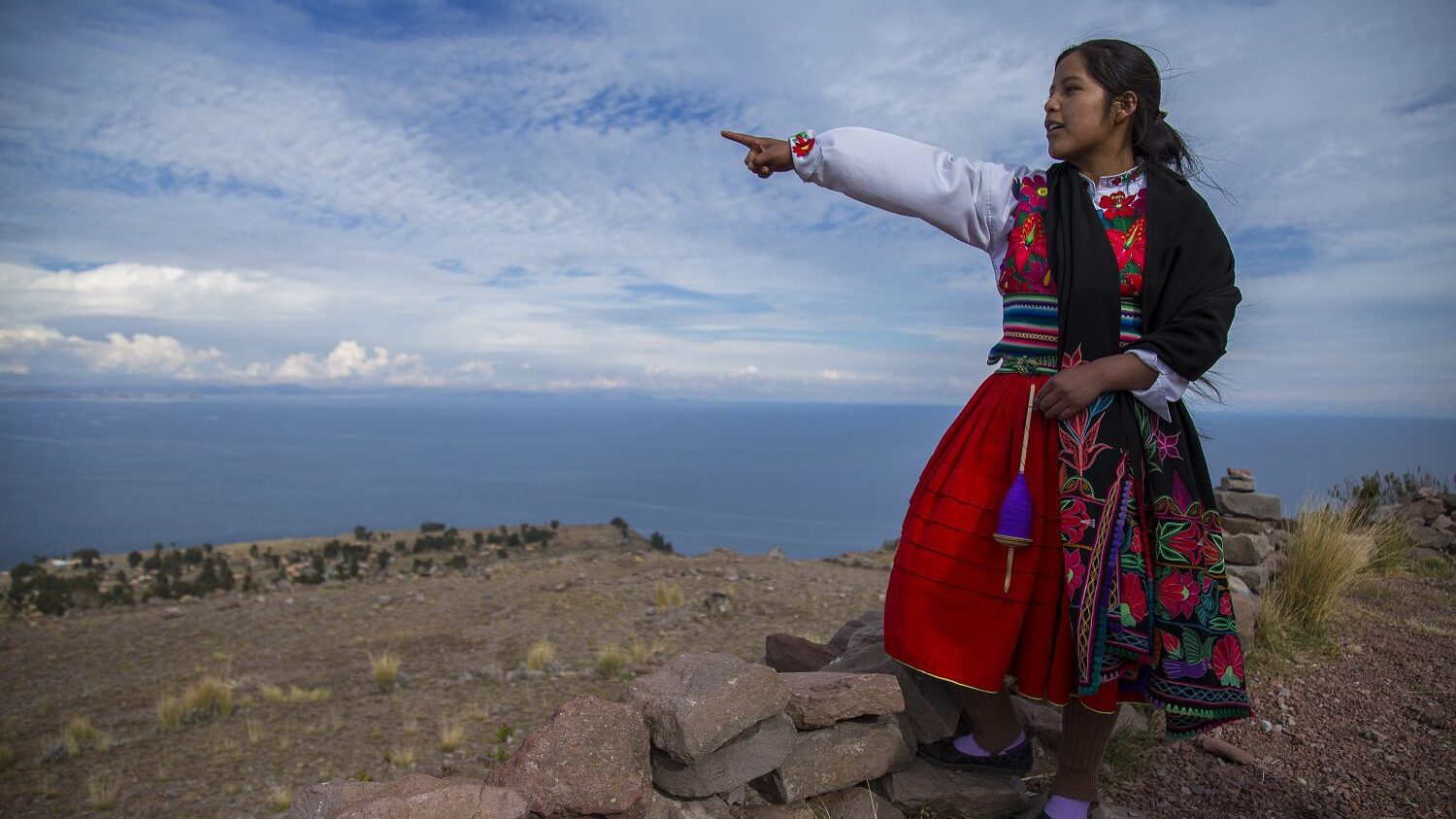 local guide points out over Lake Titicaca from Amantani Island