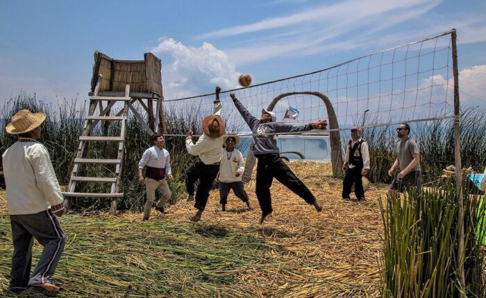 Travelers and locals playing volleyball together on a visit to the floating Uros Titino islands at Lake Titicaca - RESPONSible Travel Peru