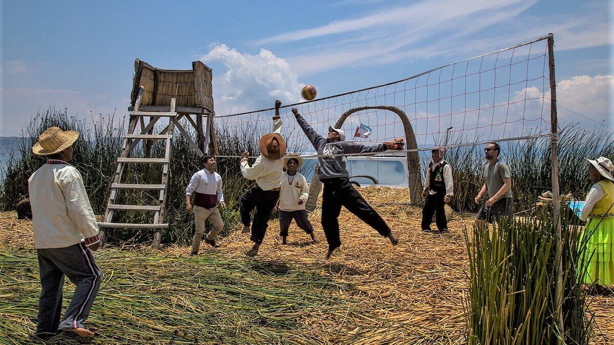 Travelers and locals playing volleyball together on a visit to the floating Uros Titino islands at Lake Titicaca - RESPONSible Travel Peru