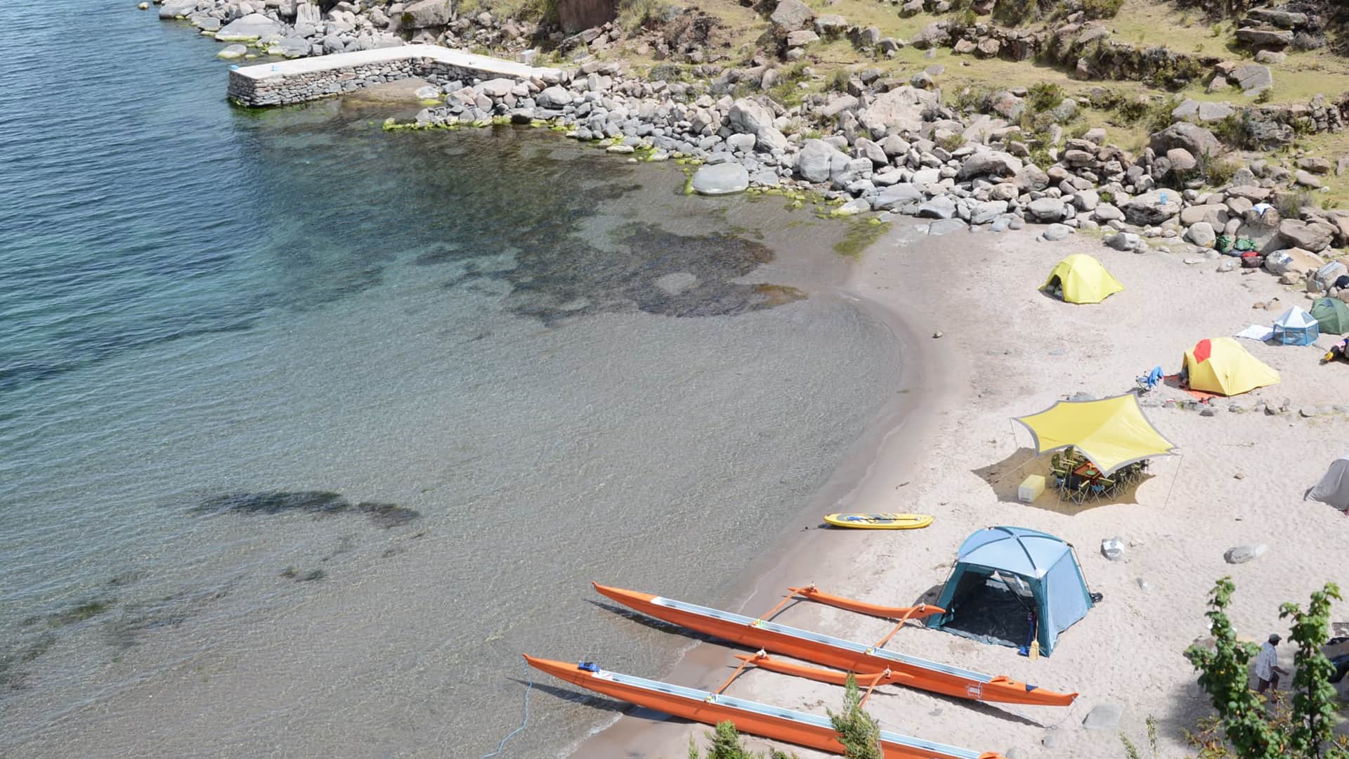 Aerial view of Paramis camping site with tents and canoes at the beach | Responsible Travel Peru