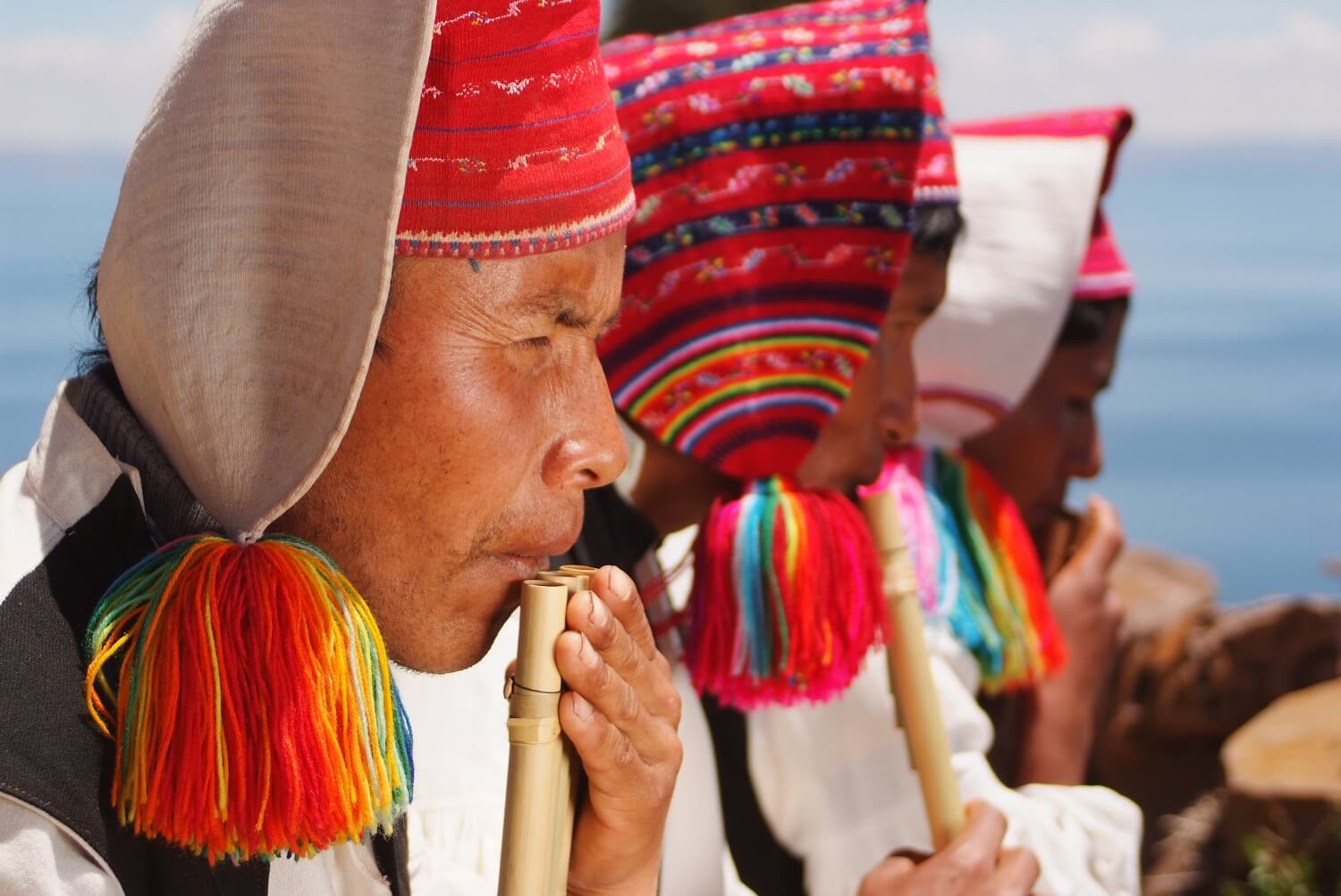 11Colorful local men from Taquile island playing traditional instruments. Travel deeper with RESPONSible Travel Peru