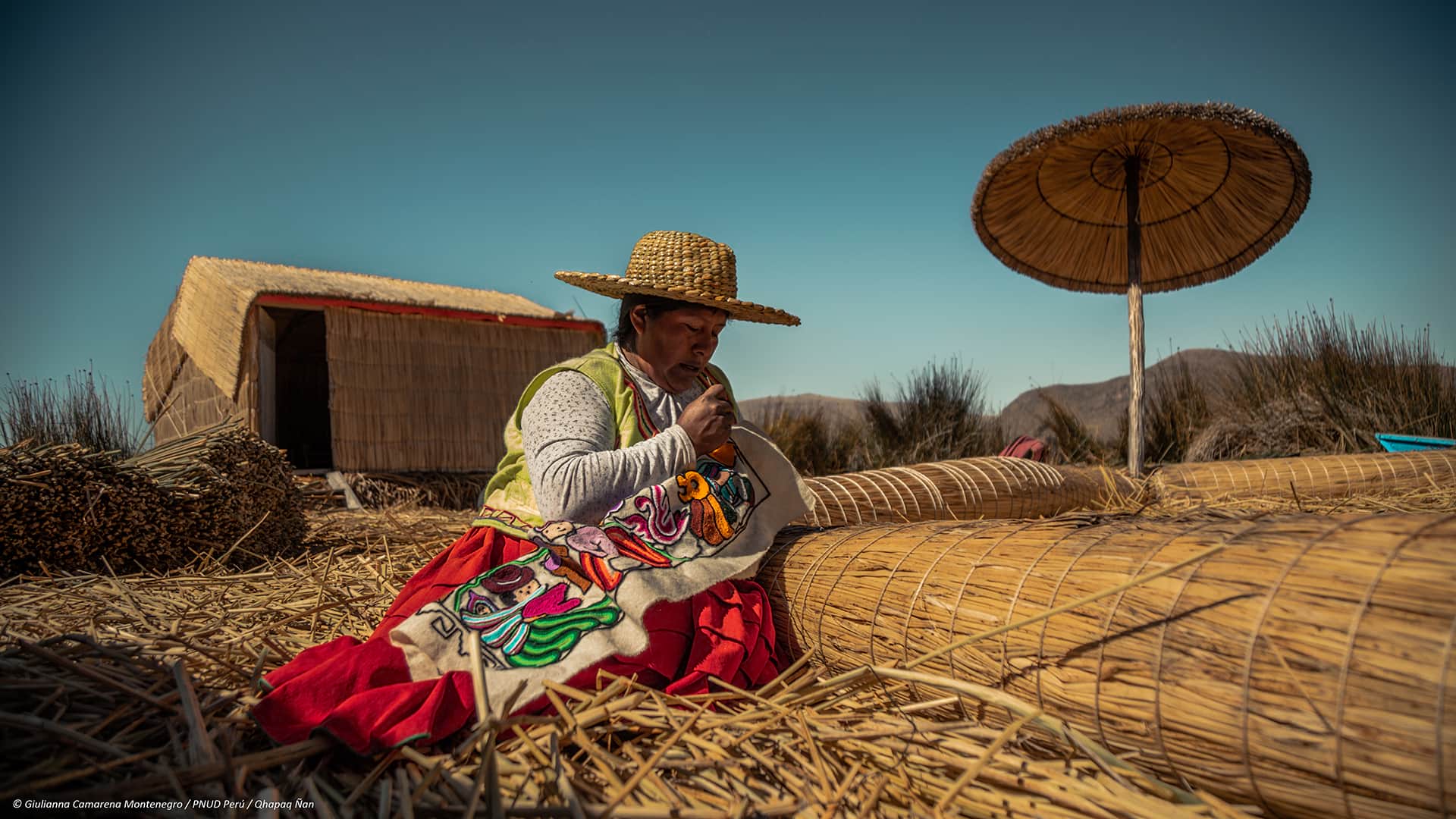 11Woman sitting on island floor while embroidering a piece of cloth | Responsible Travel Peru