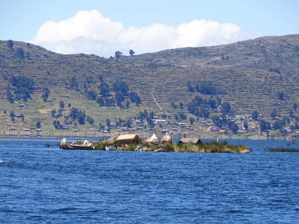 One of the lesser visited Uros Titino floating reed islands with Llachón on the background. Visit Lake Titicaca's hidden gems with RESPONSible Travel Peru!