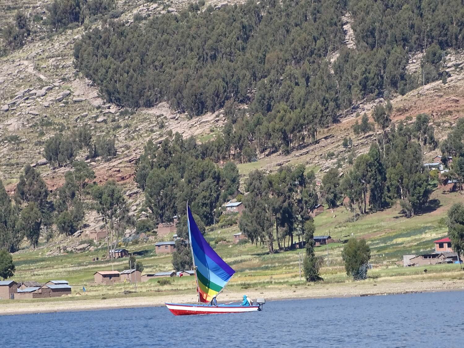 11Sailboat with a sail in the colors of the Inca flag sailing by the shores of Capachica | RESPONSible Travel Peru