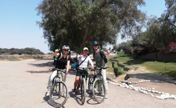 Travelers and local guide arriving to Cantayoc aqueducts on bicycles