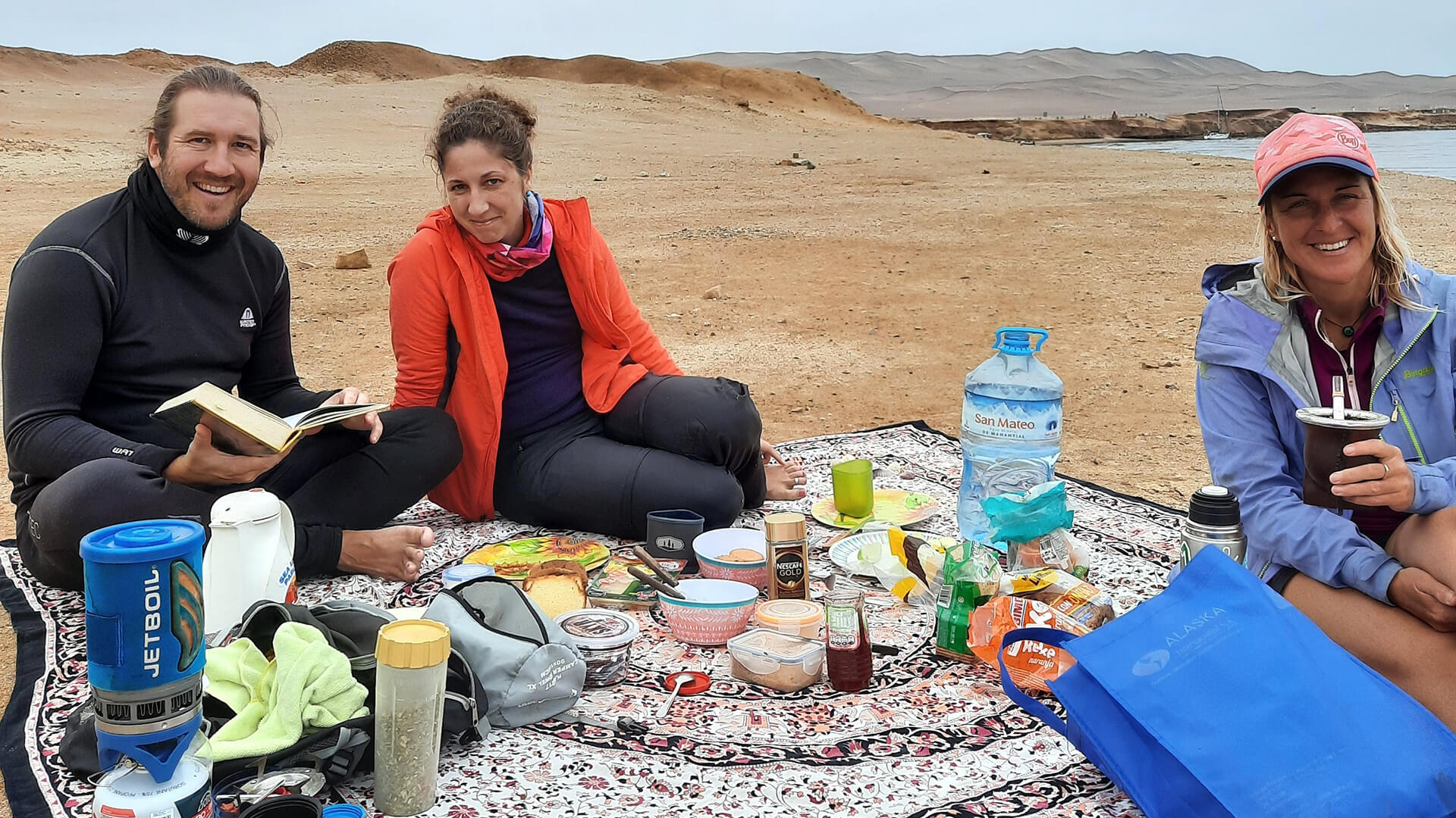 One guy and two girls picnicing in Paracas beach - RESPONSible Travel Peru