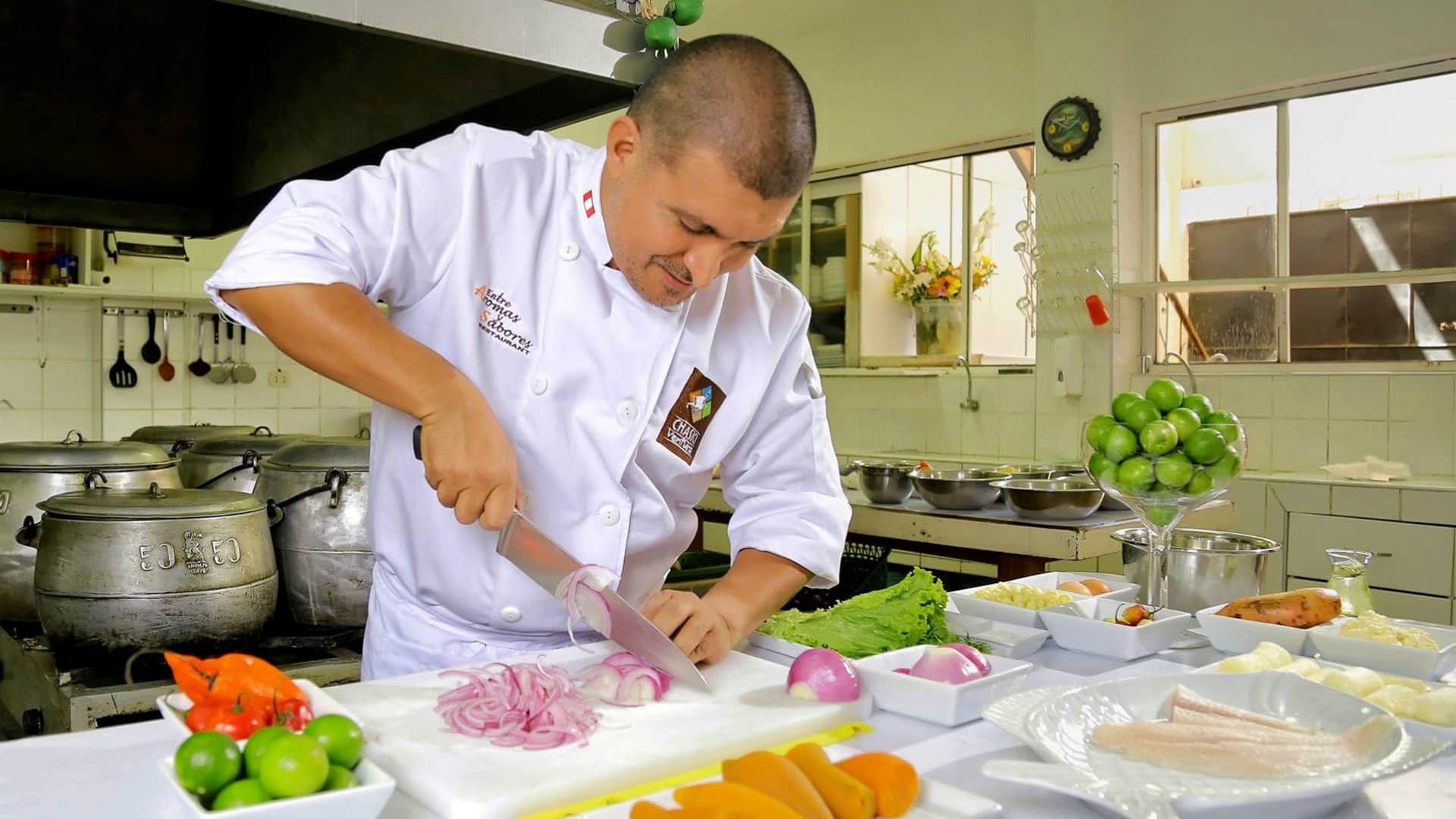 11Chef working over cutting board and many ingredients all over the kitchen table | Responsible Travel Peru