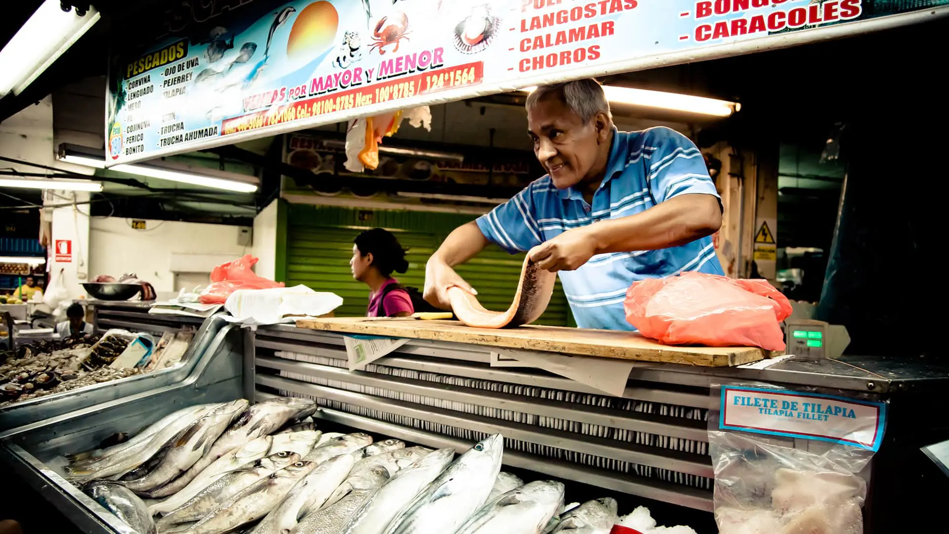Fish vendor showing his product at the market | Responsible Travel Peru