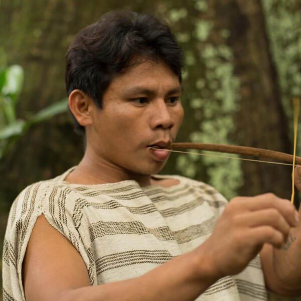 Matsigenka young man playing mouth violin in Manu | Responsible Travel Peru