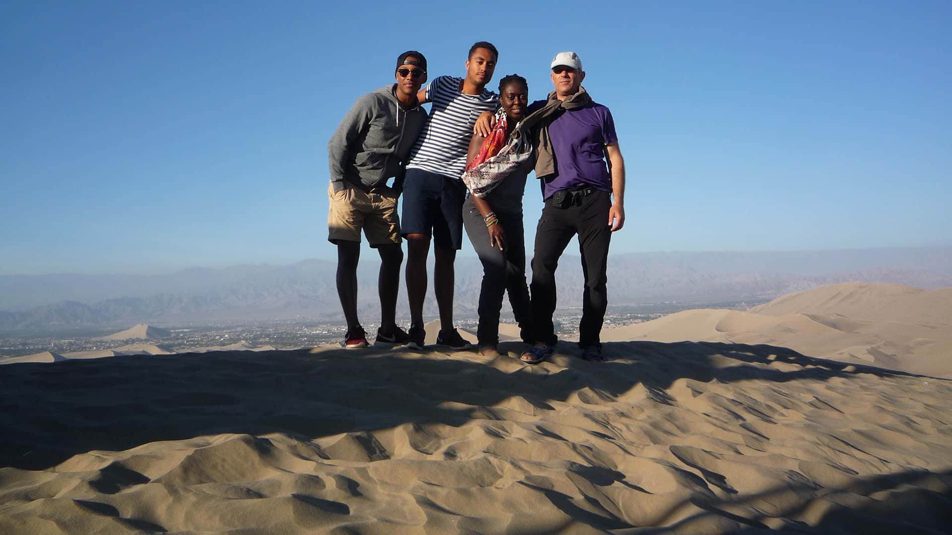 The Becker family on top of a dune in the desert of Nazca | RESPONSible Travel Peru