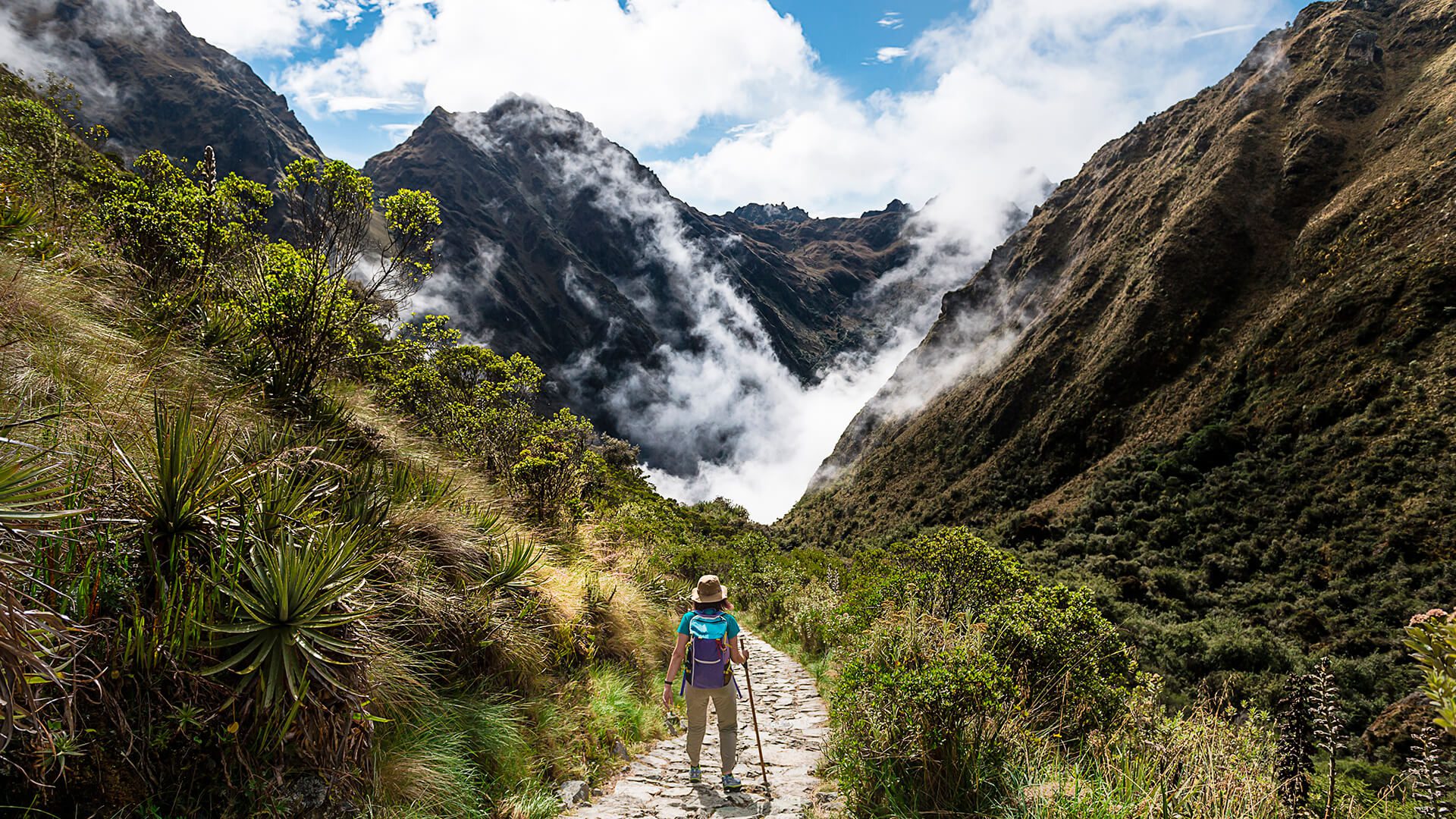 11Woman standing on the Inca Trail among mountains, vegetation and clouds | RESPONSible Travel Peru