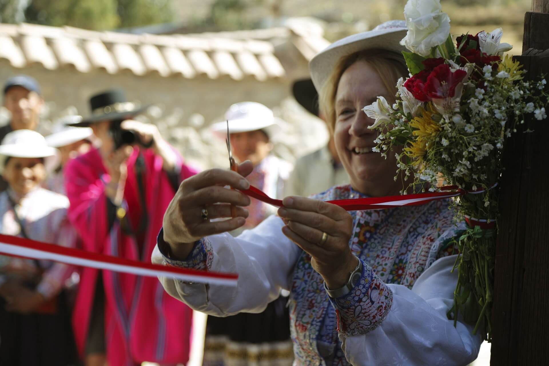 Marianne cutting the ribbon, officially opening the rebuilt homestays in Coporaque. Community-Based Tourism in Peru with RESPONSible Travel Peru.
