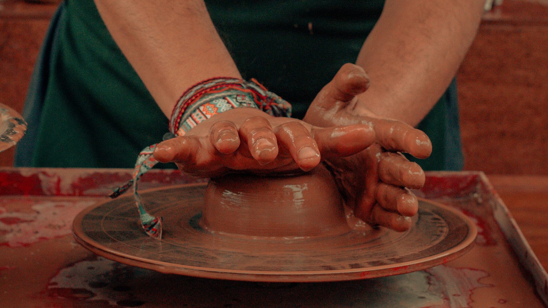 Hands on clay giving shape over a turnstile - RESPONSible Travel Peru